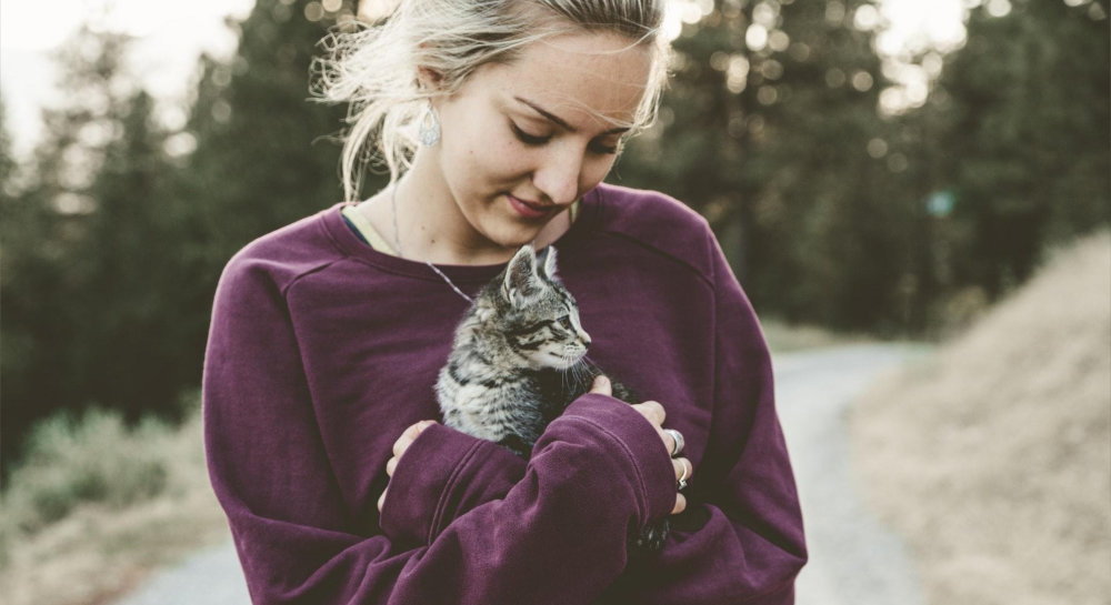 a woman gently holding her cat